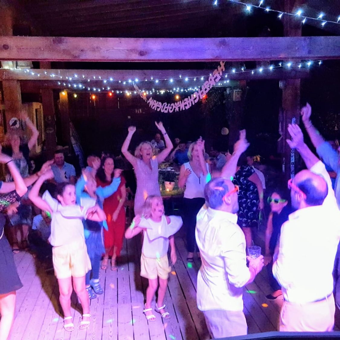 Auenwaldstation Leipzig Menschen tanzen und feiern auf einer bunten Party mit Lichtern und Musik.