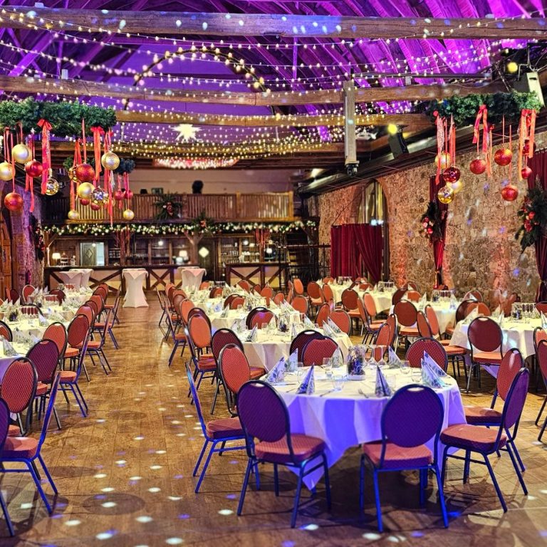 Festlich dekorierter Saal mit gedeckten Tischen und buntem Lichteffekten