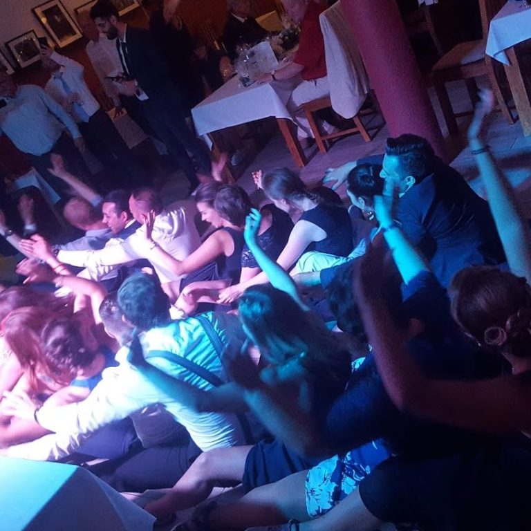 Firmenfeier Noahs Zwenkau Menschen tanzen und feiern in einem beleuchteten Raum, fröhliche Stimmung.